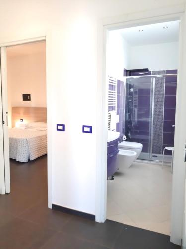 a bathroom with a sink and a toilet and a bed at RipamontiBnB in Milan