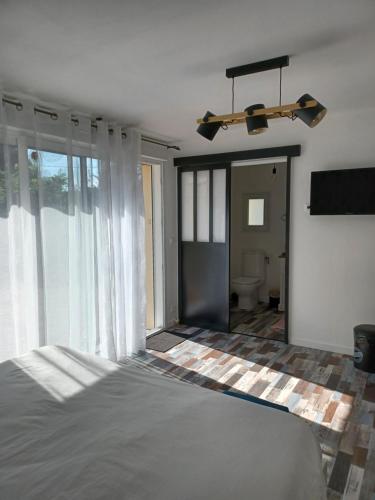 a bedroom with a bed and a large window at Chambre d’hôtes des tourterelles in Champniers