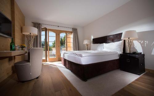 Hotel des Alpes Superieur في غشتاد: غرفة نوم كبيرة مع سرير كبير ونافذة