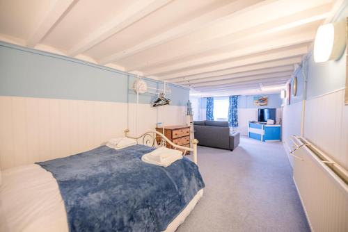 Un dormitorio con una cama y una sala de estar. en Settled In, Aldeburgh, en Aldeburgh
