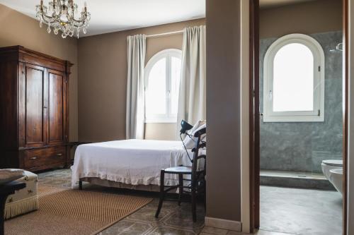 a bedroom with a bed and a tub and windows at Casa di Melo - Organic Country Hotel in Cassibile