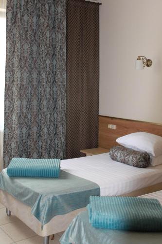 Dos camas en una habitación de hotel con almohadas azules. en Art-Room "Чистые ключи", en Yaroslavl