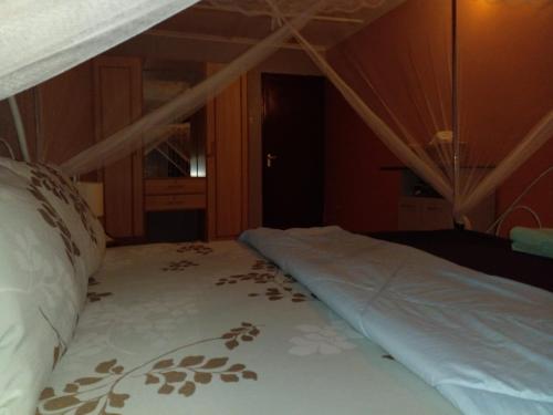 a bed in a room with a wooden ceiling at Elegance & Simplicity in Mombasa