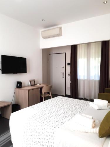 a bedroom with a bed and a desk and a tv at RipamontiBnB in Milan
