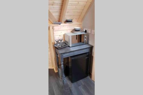 a small kitchen in a tiny house with a microwave at Unique luxury cabin in Inverness