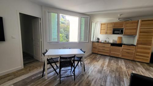 - une cuisine avec une table et deux chaises dans l'établissement CASSIS CENTRE Magnifique Appartement à 2 mn de la plage et du Port, tous les commerces à proximité idéalement placé, à Cassis
