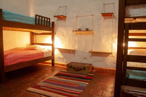 a bedroom with two bunk beds and a rug at Nacuma Garden Hostel - Casa Nacuma in Barichara