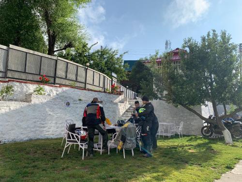a group of people standing around a table in the grass at Hotel Rollingrang in Kalpa