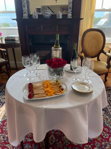 uma mesa com um prato de queijo e taças de vinho em Almondy Inn Bed & Breakfast em Newport