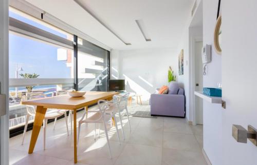 a kitchen and dining room with a table and chairs at Seafront Boutique CalaBeach Rincón de la Victoria in Cala del Moral