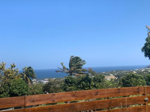 a wooden fence with the ocean in the background at Maison avec piscine chauffée - 8 personnes - Sud Réunion in Saint-Joseph