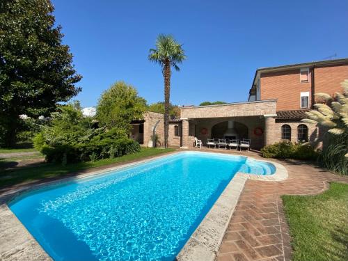 basen przed domem z palmą w obiekcie Dama Estense w mieście Copparo