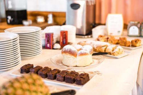 a table topped with plates of pastries and desserts at NaturResidence Dolomitenhof in Siusi