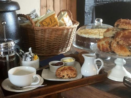 a table with a tray of pastries and cups of coffee at Balsporran Bed and Breakfast in Dalwhinnie