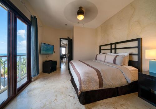 プラヤ・デル・カルメンにあるCondo Surf 407 - Beachfront Oceanview 1 Bedroom Condo Rental - at El Faro condosのベッドルーム1室(ベッド1台、大きな窓付)
