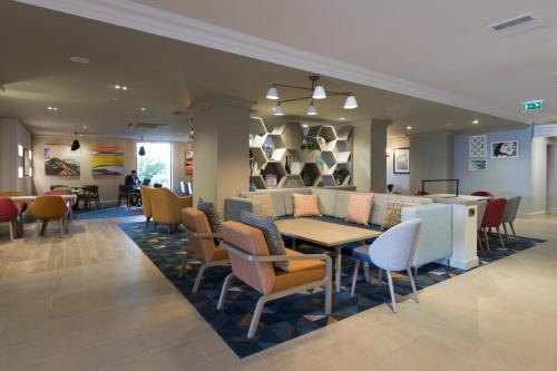 uma sala de jantar com mesa e cadeiras em Holiday Inn - Glasgow Airport, an IHG Hotel em Paisley