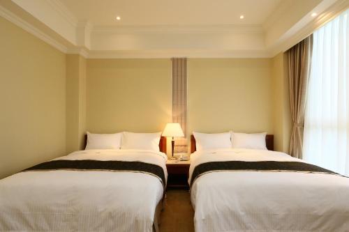 two beds in a room with a window at Aleex Villa in Yuanshan