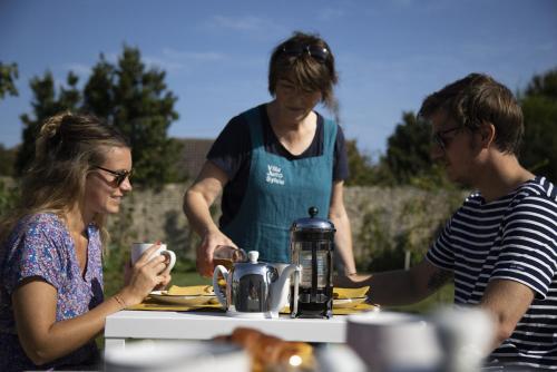 un groupe de personnes debout autour d'une table dans l'établissement Villa Juno - Saint-Aubin-sur-Mer - Côte de nacre - Normandie - Plage débarquement, à Saint-Aubin-sur-Mer