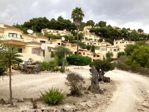 a group of houses on a hill with a dirt road at 4 persoons bungalow met gemeenschappelijk zwembad in Teulada