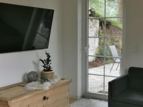 a living room with a tv on a wall at Ferienhaus Glücksgriff Pottenstein in Pottenstein