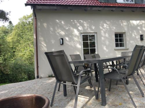 a black table and chairs on a patio at Ferienhaus Glücksgriff Pottenstein in Pottenstein