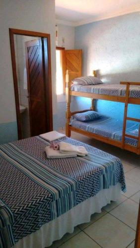 a bedroom with two beds and a swimming pool at Pousada Maresia do Sargi in Uruçuca