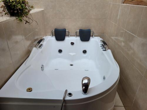bañera blanca con 2 sillas encima en Mindo GlamBird Glamping & Lodge en Mindo
