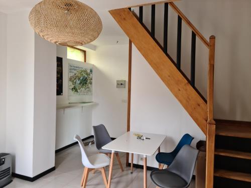 une salle à manger avec une table et des chaises blanches dans l'établissement Maison La Cigogne Noire, à La Loge-aux-Chèvres