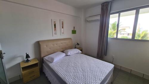 ein kleines Schlafzimmer mit einem Bett und einem Fenster in der Unterkunft PRAIA DE 4 ILHAS Apartamento 2 Quartos 60M Da Praia Com Vista in Bombinhas