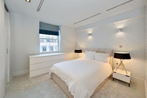 a white bedroom with a white bed and a window at London Choice Apartments - Mayfair - Bond Street in London