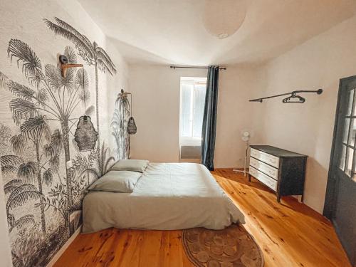 1 dormitorio con 1 cama y un dibujo en la pared en Superbe T2 avec cours, en Carmaux