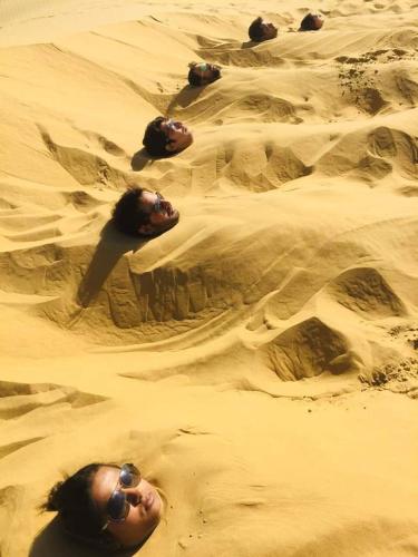 a group of people laying in the sand at Excellent Desert Safari camp in Sām