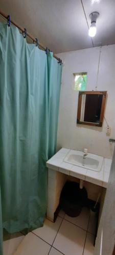 a bathroom with a shower curtain and a sink at Tropical Dreams Hostel in Corn Island
