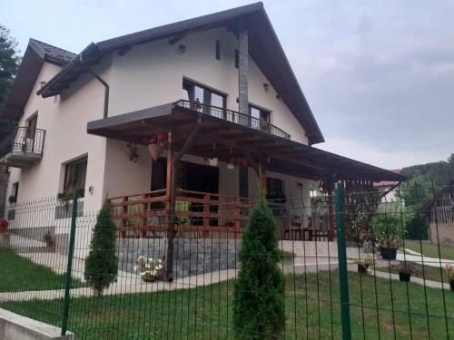 una casa bianca con portico e recinzione di Casa Alex a Curtea de Argeş