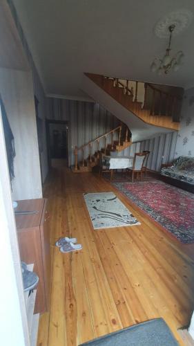 a living room with a wooden floor and a staircase at Дом в Хырдалане in Xirdalan