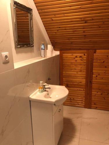 a bathroom with a white sink and a window at Gold Apartman in Zamárdi