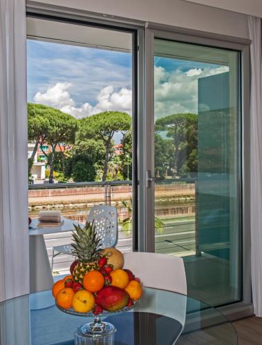 a bowl of fruit on a glass table in front of a window at Hotel Viareggio in Viareggio
