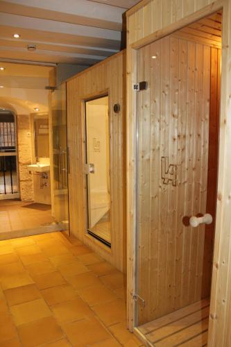 a bathroom with wooden walls and a glass door at Hotel Leonor de Aquitania in Cuenca