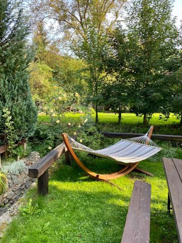 a hammock and a bench in a park at Pension Hamry in Vranov nad Dyjí