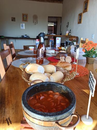 uma mesa coberta com uma tigela de sopa e sanduíches em POUSADA PATRIMÔNIO DOS SONHOS em PatrimÃ´nio da Penha
