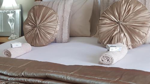 a bed with two towels and two mirrors on it at Caza Blanca Apartments ( La como Lifestyle Estate) in Boksburg