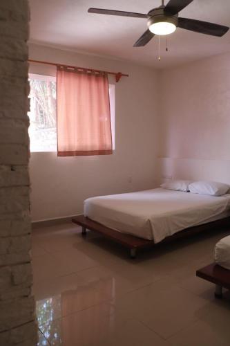 a bedroom with a bed and a ceiling fan at Casa Oved Levy in Cozumel