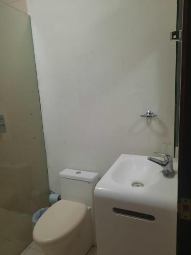 a white bathroom with a toilet and a sink at Casa Oved Levy in Cozumel