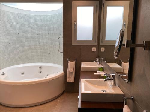 a large bathroom with two sinks and a tub at Chalet Villa turística con vistas al mar Breakfast items in the home in Faro de Cullera