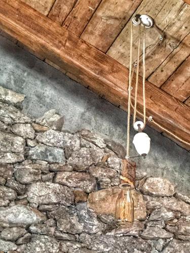 a chandelier hanging from the ceiling of a stone wall at La torretta in Pessinetto