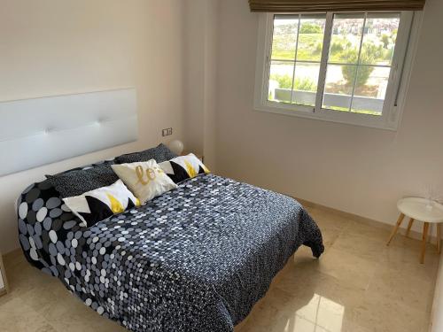 1 dormitorio con 1 cama en blanco y negro y ventana en Residencial Duquesa, en San Luis de Sabinillas