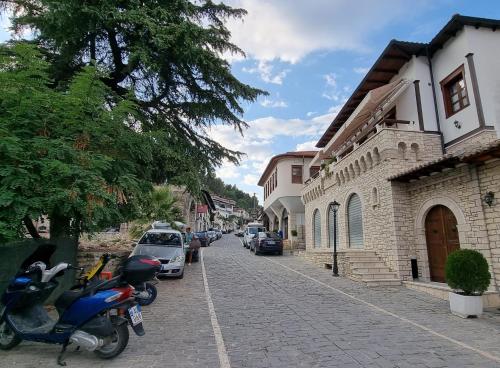 a cobblestone street with parked cars and buildings at Master Hotel in Berat