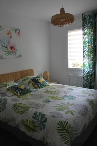 a bedroom with a bed with a green and white comforter at Chalet ILONA in Cambo-les-Bains