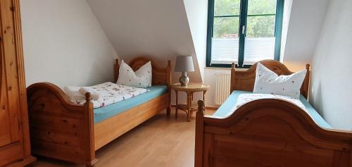 een slaapkamer met 2 aparte bedden en een raam bij Ferienhaus Hase in Burg