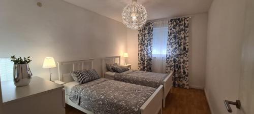 sypialnia z 2 łóżkami i żyrandolem w obiekcie La Pergola w Fažanie
